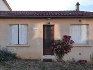 ein Haus mit zwei Fenstern, einer Tür und Blumen in der Unterkunft Le Cerizay Gîte n°1 in Cerizay