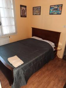ein Schlafzimmer mit einem großen Bett mit einer schwarzen Decke in der Unterkunft Le Cerizay Gîte n°1 in Cerizay