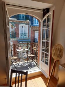 um quarto com uma varanda com uma mesa e cadeiras em Charmante Villa plein SUD 50m de la plage - Balcon vue latérale sur Mer - équipée de la Fibre, Wifi, internet em Mers-les-Bains