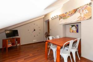 uma sala de jantar com mesa e cadeiras e uma televisão em San Salvario Apt with Balcony em Turim