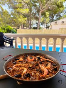 una teglia di cibo seduta sopra un tavolo di Chalet con piscina (B) a Les tres Cales