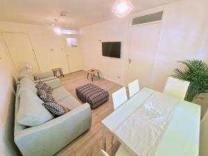 ein Wohnzimmer mit einem Sofa und einem Tisch in der Unterkunft Flat in Battersea, 5 minutes from Clapham Junction Station in London