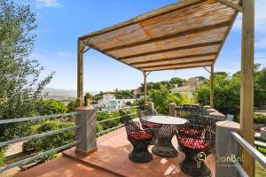 eine Terrasse mit einem Tisch und Stühlen auf dem Balkon in der Unterkunft Casa de 2 dormitorios con piscina privada y desayuno incluido en Alhaurin in Alhaurín de la Torre