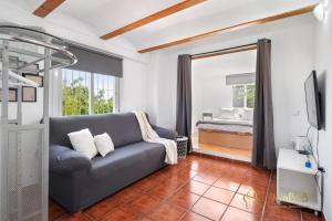 ein Wohnzimmer mit einem Sofa und einem Bett in der Unterkunft Casa de 2 dormitorios con piscina privada y desayuno incluido en Alhaurin in Alhaurín de la Torre