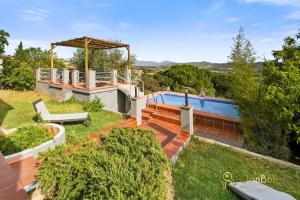 een achtertuin met een zwembad en een huis bij Casa de 2 dormitorios con piscina privada y desayuno incluido en Alhaurin in Alhaurín de la Torre