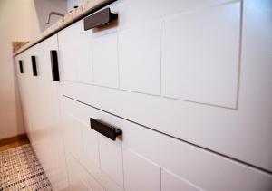 a white cabinet with black handles in a room at Baltic Breeze Studio Gdynia -stylowe studio 2-os, blisko morza in Gdynia