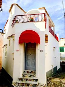 a white house with a door and a balcony at R&D Rest and Dream Capri in Anacapri