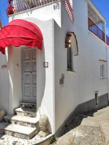 a white building with a door and a red umbrella at R&D Rest and Dream Capri in Anacapri