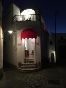 un bâtiment avec un auvent rouge à l'avant dans l'établissement R&D Rest and Dream Capri, à Anacapri