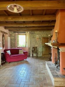 sala de estar con sofá rojo y chimenea en Sambuco di Sopra en Fratticciola Selvatica