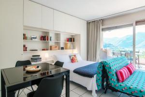 a bedroom with a desk and a bed and a window at Panoramic Studio by Quokka 360 - Open Space Apartment with Terrace in Lugano