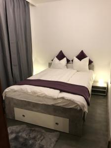 a bedroom with a large bed with purple and white pillows at Ski and Lake View Apartment in Zell am See