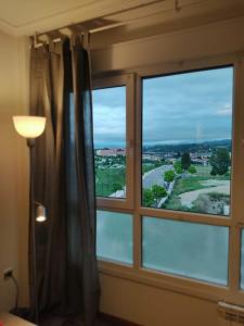 een raam in een kamer met uitzicht op het water bij Apartamento Gloria en Oviedo in Oviedo