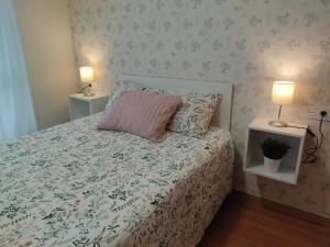 1 dormitorio con 1 cama con almohada rosa y 2 lámparas en Apartamento Gloria en Oviedo, en Oviedo