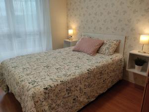 een slaapkamer met een bed, 2 lampen en een raam bij Apartamento Gloria en Oviedo in Oviedo