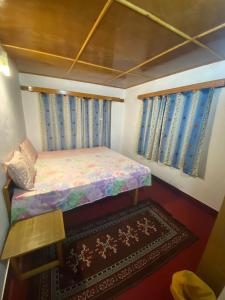 um pequeno quarto com uma cama e um tapete em Gomang guest house Leh em Leh