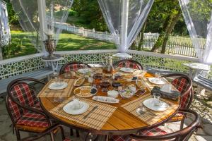 a wooden table with chairs on a porch at Chukhur Gabala Museum Hotel in Gabala