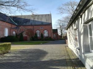een groot gebouw van rode baksteen met een groot dak bij Ferienwohnung im historischen Zentrum 25562 in Weener
