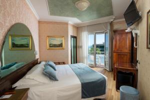 una camera con un grande letto e una televisione di Hotel Des Nations - Vintage Hotel sul mare a Riccione