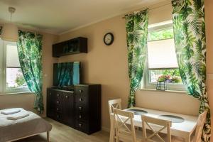 a bedroom with a table and chairs and two windows at Apartament Polaniczanka in Polanica-Zdrój