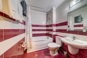 La salle de bains est pourvue de toilettes blanches et d'un lavabo. dans l'établissement Colorful 2BD Apartment with Indoor Fireplace and Mountain View, à Pamporovo