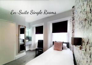 a bedroom with a bed and a sign that reads an suite single rooms at Allerdale Court Hotel in Cockermouth