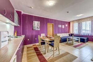 une cuisine et une salle à manger avec un mur pourpre dans l'établissement Colorful 2BD Apartment with Indoor Fireplace and Mountain View, à Pamporovo