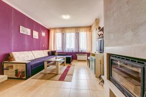 - un salon avec un canapé et une cheminée dans l'établissement Colorful 2BD Apartment with Indoor Fireplace and Mountain View, à Pamporovo