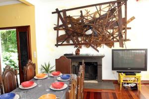een eetkamer met een tafel met een televisie en een open haard bij Family Holiday Villa Vacations Ponta Delgada in Ponta Delgada