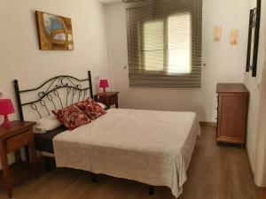 a bedroom with a bed and two tables and a window at APARTAMENTO NATURISTA in Playas de Vera +4 photos
