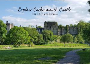 a castle in the middle of a field with a path at Allerdale Court Hotel in Cockermouth