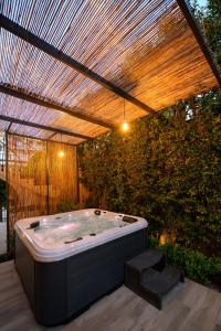 uma banheira de hidromassagem num pátio com uma pérgola em Linas Home - Kalamata Mediterranean Villas em Kalamata
