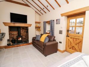 a living room with a couch and a fireplace at The Old Cobblers Shop in Llandrindod Wells