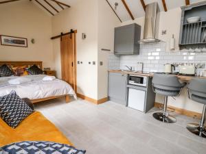 a kitchen and a bedroom with a bed and a counter at The Old Cobblers Shop in Llandrindod Wells