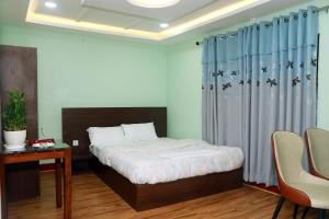 una camera da letto con un letto, un tavolo e delle sedie di Kathway Hostel & Homestay a Kathmandu