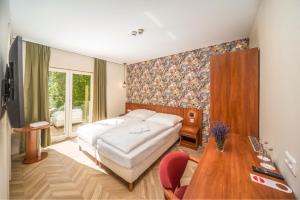 sypialnia z łóżkiem i drewnianym stołem w obiekcie Hotel Csillag Tokaj w Tokaju