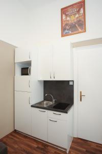 a kitchen with white cabinets and a sink at Apartments Vienna Opera in Vienna