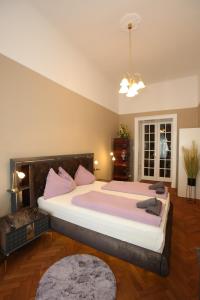 een slaapkamer met een groot bed met roze kussens bij Apartments Vienna Opera in Wenen