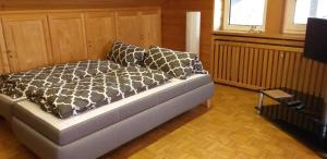 Bett mit schwarzen und weißen Kissen in einem Zimmer in der Unterkunft 2-Zimmer DG-Apartment mit eigener Sauna in Oberhaching
