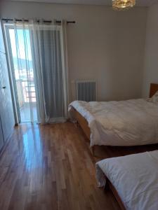 ein Schlafzimmer mit zwei Betten und einem großen Fenster in der Unterkunft Great apartment with parking in the city center in Tripolis