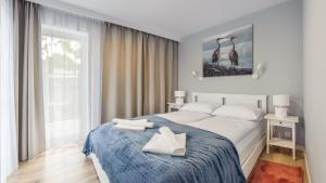 sypialnia z łóżkiem z dwoma białymi butami w obiekcie Apartamenty Sun & Snow Baltic Apartments z basenem w Pobierowie