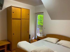 a bedroom with two beds and a cabinet and a window at Apartmani vila Todor in Divčibare