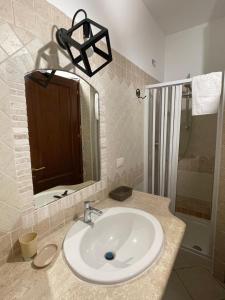 Un baño con lavabo, espejo y ducha. en Azienda agrituristica contras, en Olbia 41 fotos más