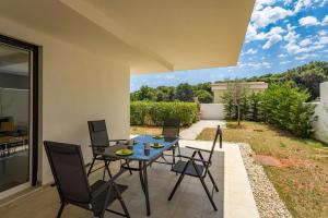 un patio con mesa y sillas y un jardín en Apartments at Villa Frida, en Premantura