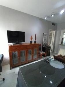 a living room with a flat screen tv on a entertainment center at Cozy apartment & free parking in Seville