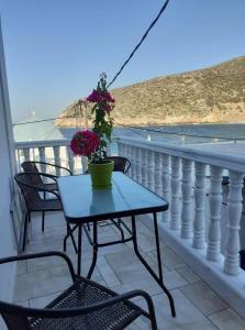 uma mesa e cadeiras numa varanda com vista para o oceano em Anastasia House em Apollon