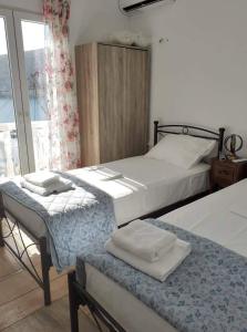 1 dormitorio con 2 camas y ventana en Anastasia House en Apollon