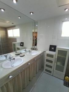 łazienka z 2 umywalkami i dużym lustrem w obiekcie Cozy apartment & free parking w Sewilli