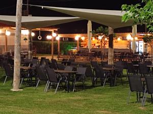 a group of tables and chairs under a pavilion at night at Hotel Alexandros in Doxato