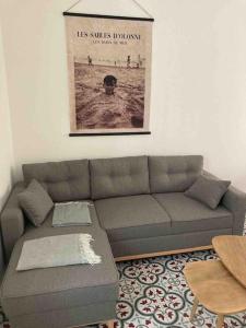 a living room with a couch and a picture on the wall at Jolie maison de pêcheur ARAGO aux Sables d'Olonne in Les Sables-dʼOlonne